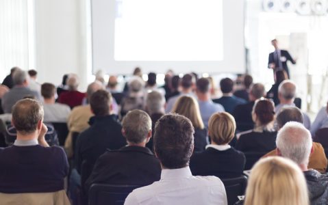 Szenario einer Fachtagung. Zuhörer und ein Referent.